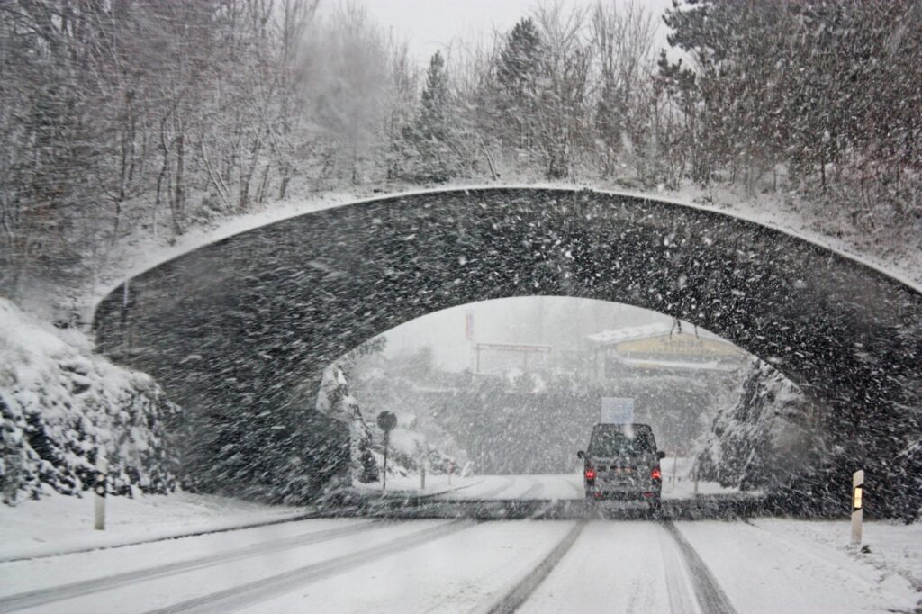 Car with winter tires driving through snow storm in alberta